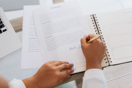 Hands signing an agreement at a desk — photo by Kaboompics on Pexels