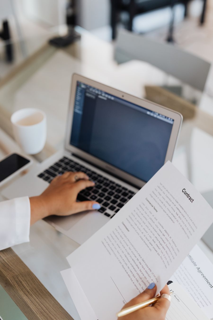 Person reviewing a contract beside a laptop — photo by www.kaboompics.com on Pexels