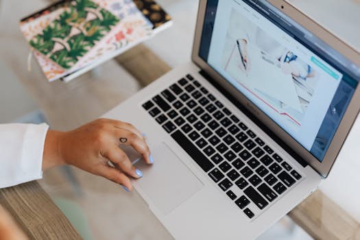 Close-up of a person using a laptop at a desk, focusing on technology and efficiency.