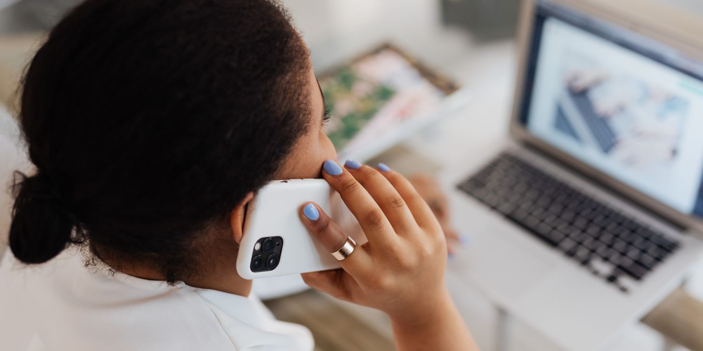 A traveler on the phone and laptop sorting out a hotel cancellation
