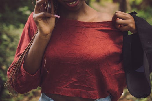 A young woman in a red top speaks on a cellphone outdoors in Ruaka, Kenya.
