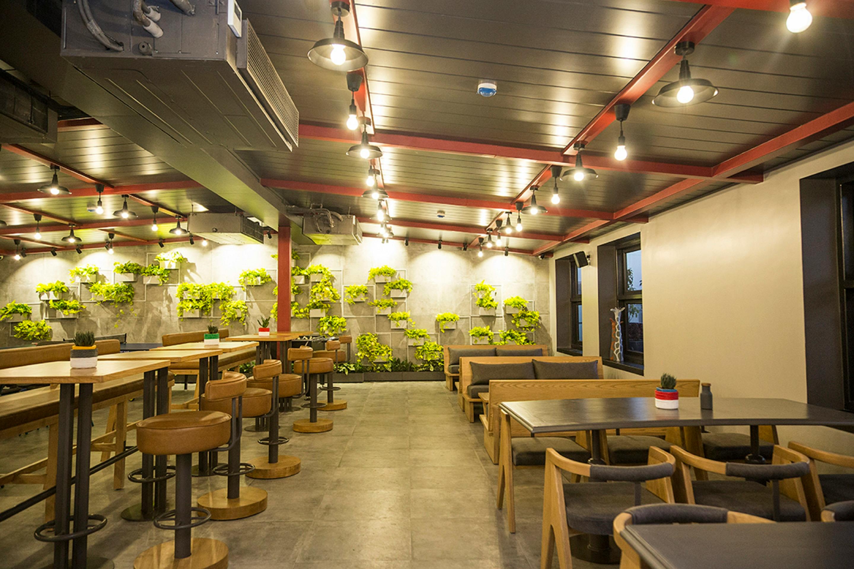 Free Contemporary indoor seating with greenery walls and ambient lighting in a modern design. Stock Photo