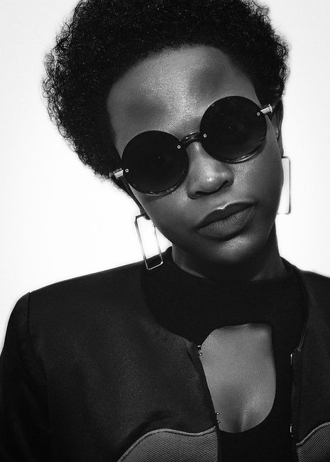 Black and white crop confident African American female in stylish sunglasses and accessories in studio with white background