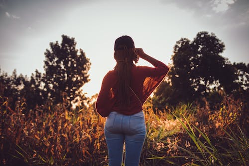 Woman Standing on a Field at Sunset 