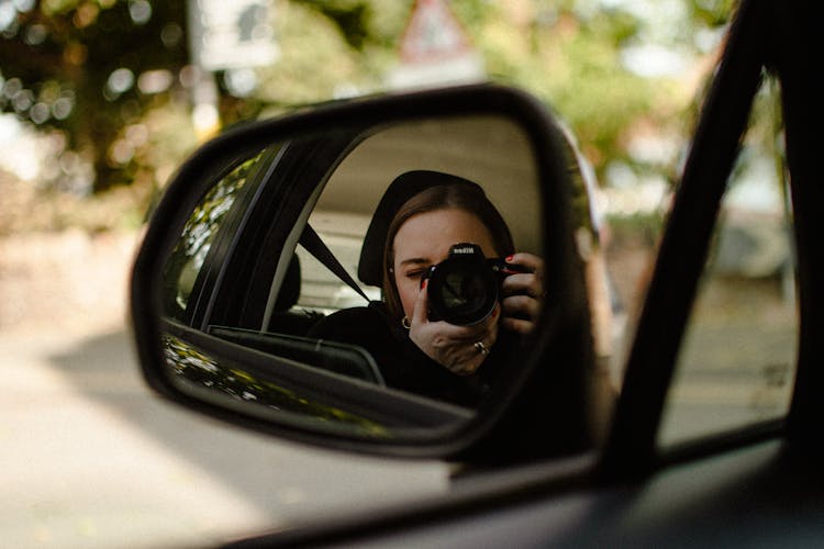 Woman Taking Selfie In Car Side Mirror