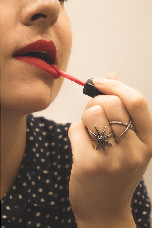 Close-Up View of Person Applying Red Lipstick