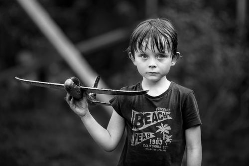 Free A young boy holding a toy airplane, embodying childhood innocence in a black and white photo. Stock Photo
