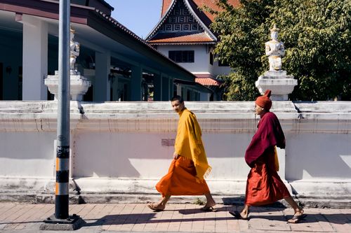 Free Two monks walking along a temple in Chiang Mai, Thailand, wearing saffron robes. Stock Photo