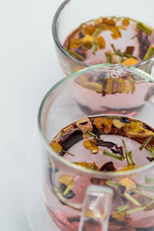 Glass cups of herbal tea on white table