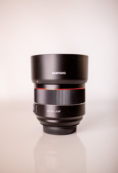 Contemporary objective for professional photo camera placed on lens mount on white shiny desk in studio