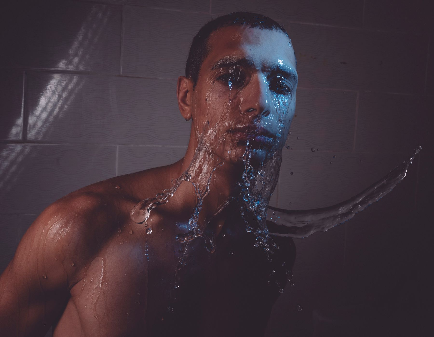 A figure lit against darkness, water breaking around him — photo by mohamed abdelghaffar on Pexels