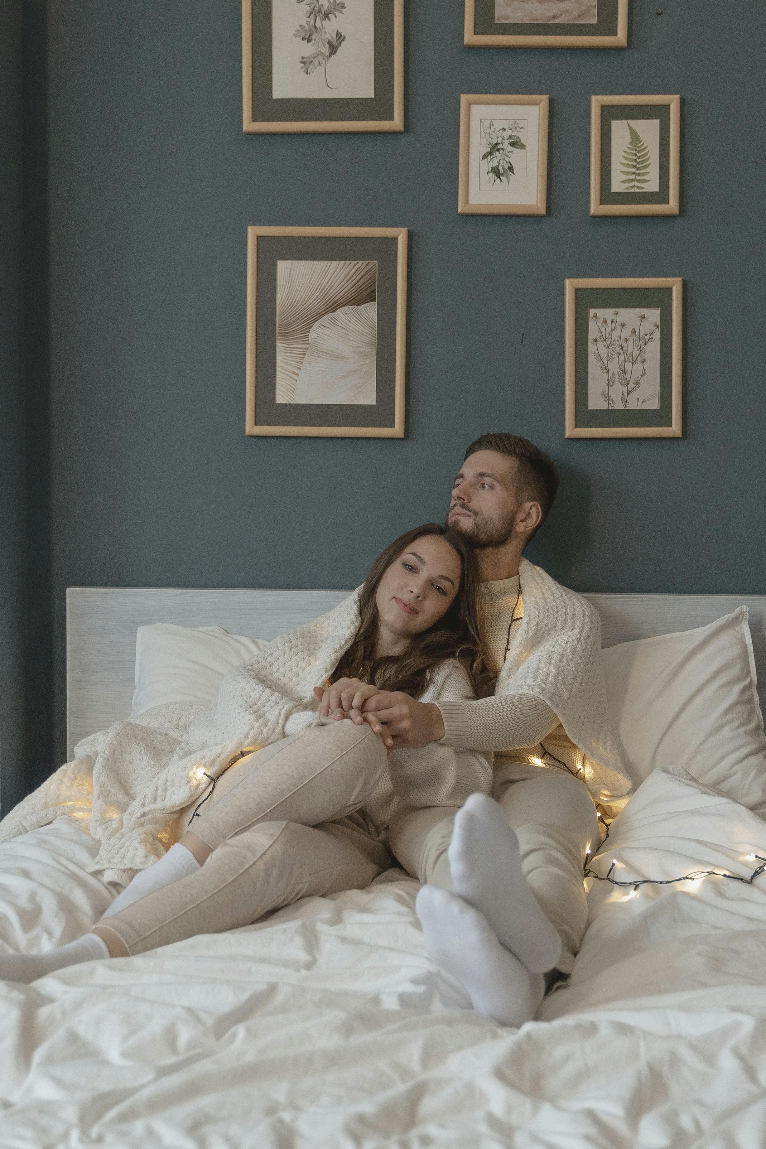 一对恩爱的夫妇在室内温暖的灯光下，于床上享受着舒适的时刻