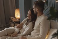 A Romantic Couple Sitting on Bed Next to Each Other