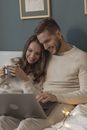 A Romantic Couple Sitting on Bed Next to Each Other while Watching a Movie