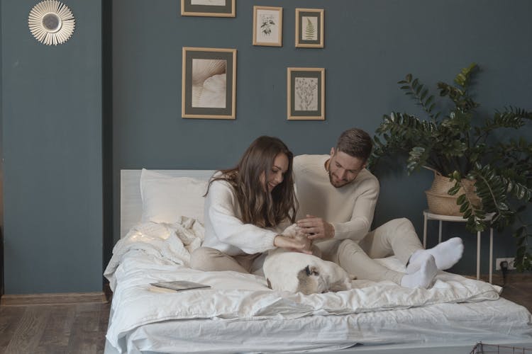 A Couple Cuddling Their Cute Dog