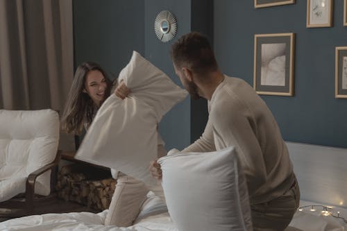 Free A Couple Having Fun Playing Pillow Fight Stock Photo