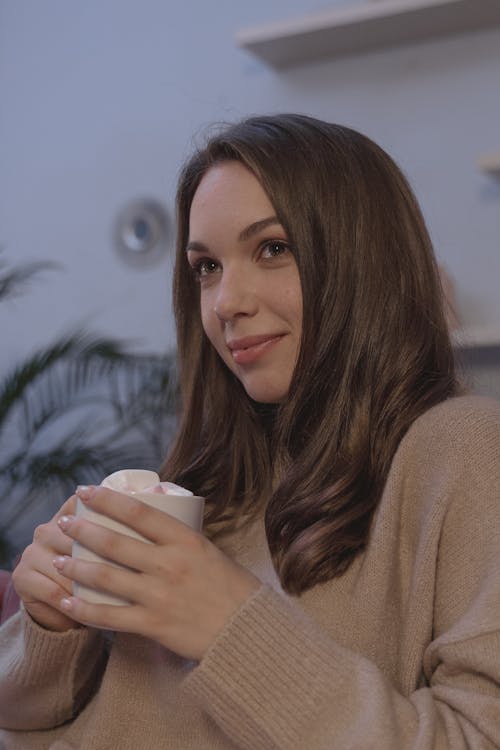 Woman in Brown Sweater Holding a Mug