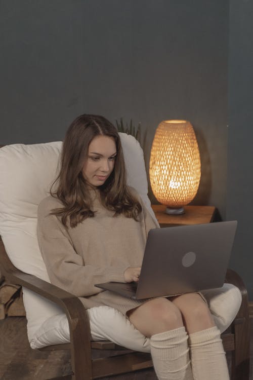 Woman in Brown Sweater Using Her Laptop