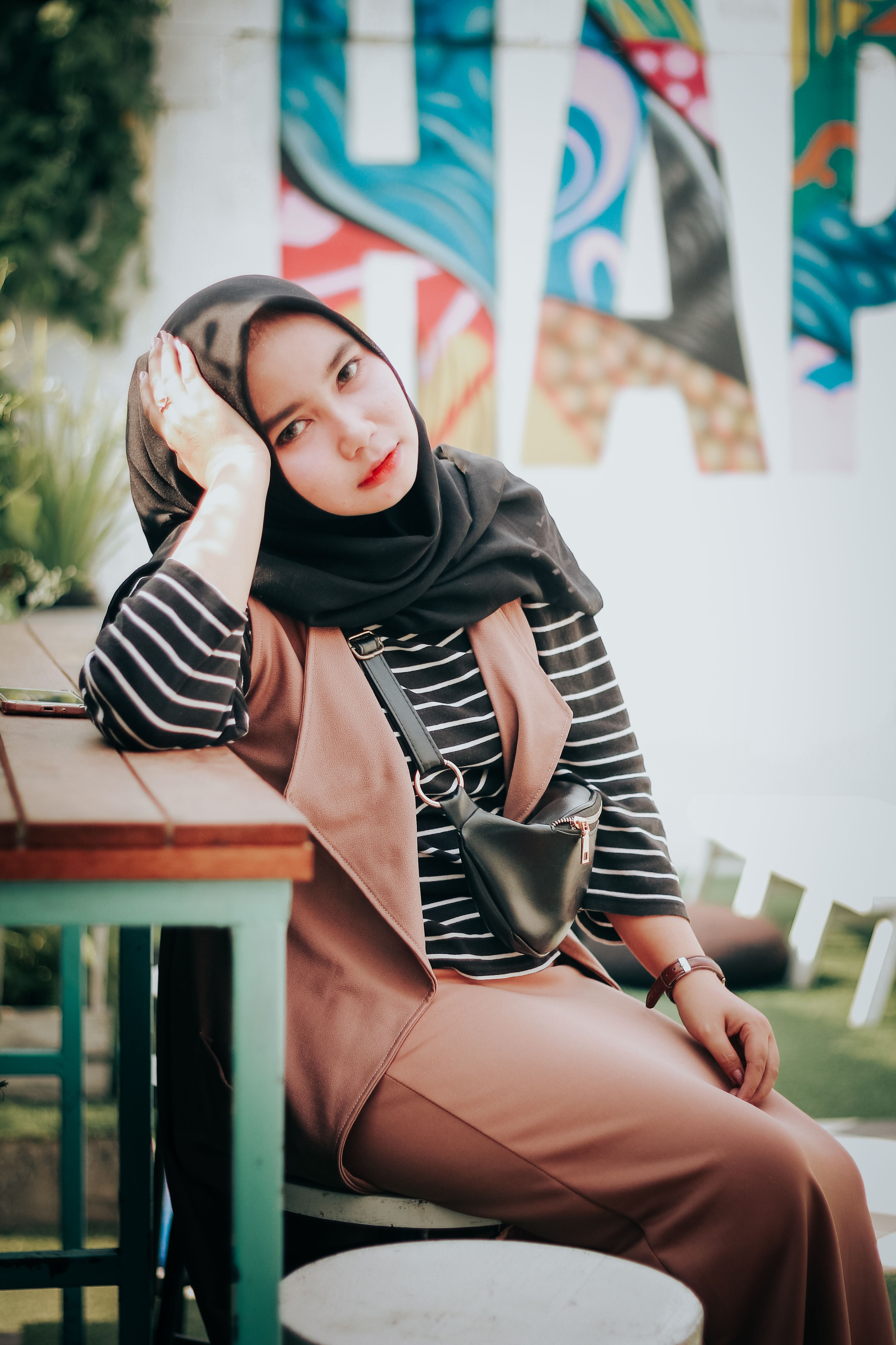 Woman in Black Hijab Sitting on Picnic Table · Free Stock Photo