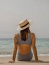 一名戴帽子的女子在海滩享受阳光明媚的一天的宁静场景