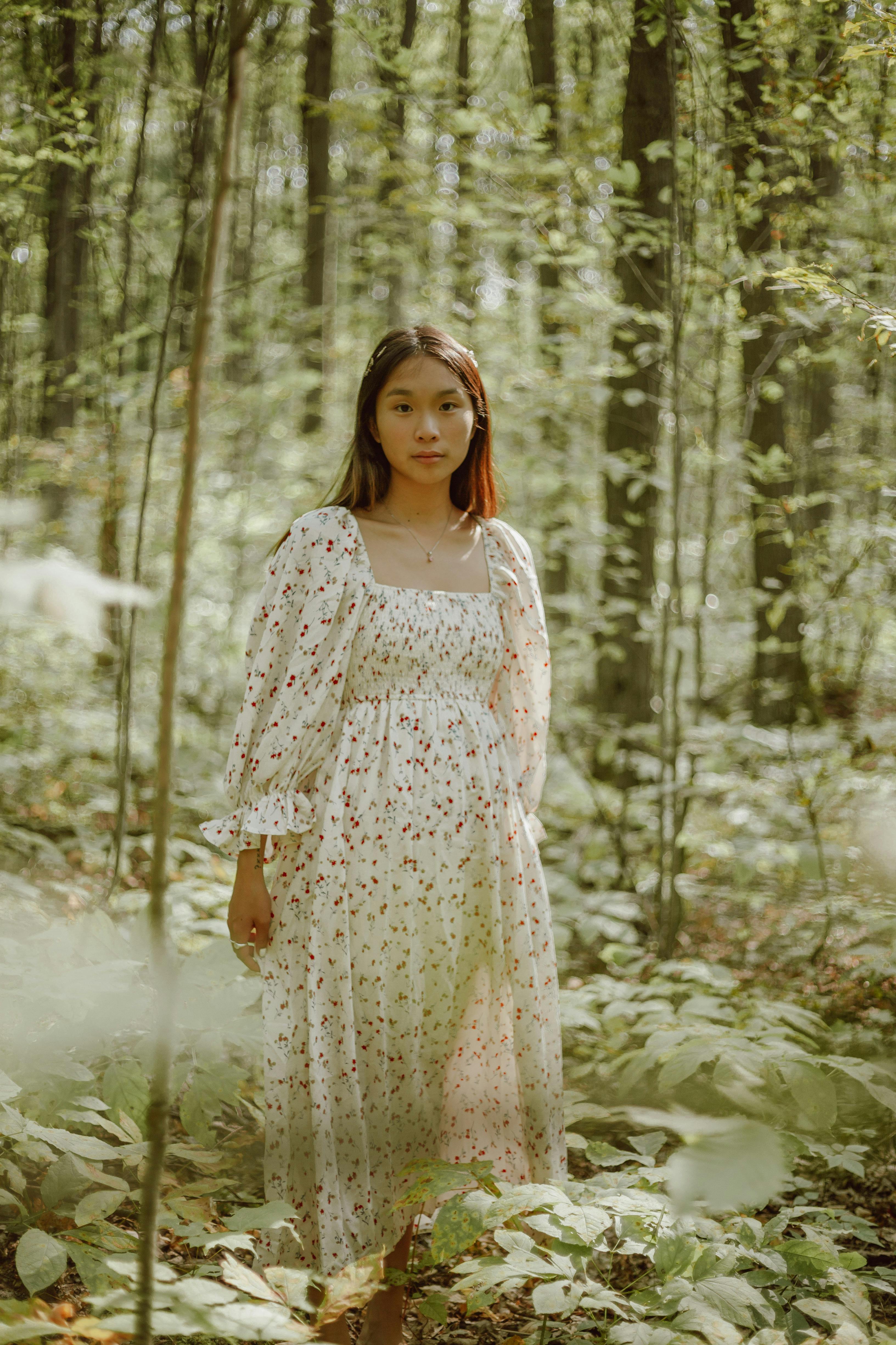 宁静的森林中，一位身着优雅花卉礼服的年轻女子，捕捉到了一个宁静的时刻