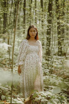 宁静的森林中，一位身着优雅花卉礼服的年轻女子，捕捉到了一个宁静的时刻