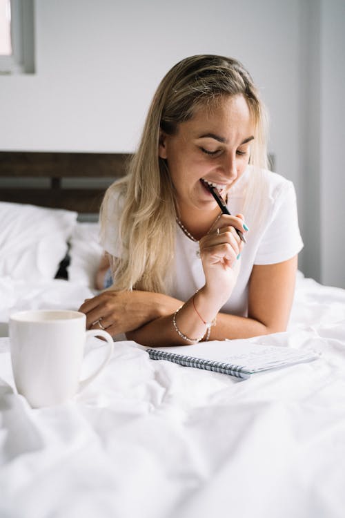 Vrouw In Wit Overhemd Met Pen En Boek