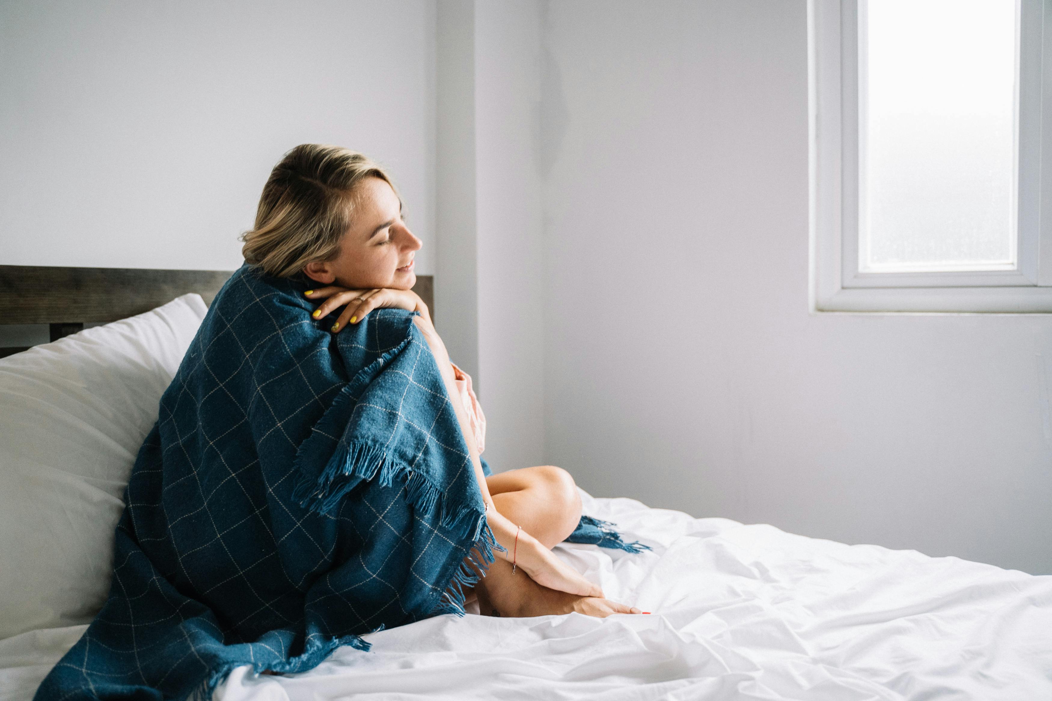 Woman Covered with a Blue Blanket Sitting on Bed · Free Stock Photo