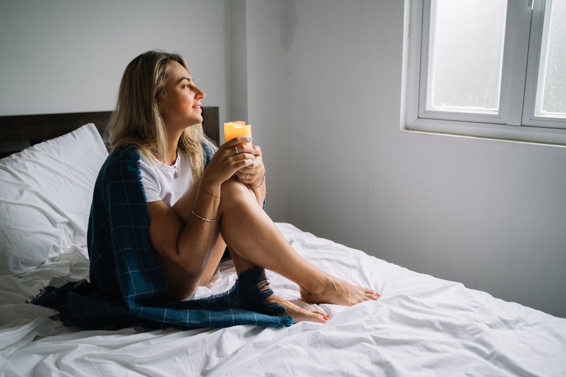 adhd lost sense of self adhd diagnosis adhd identity — woman sitting on bed morning light thoughtful window soft blanket