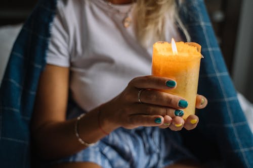 Close Up Photo of a Person Holding a Lighted Candle