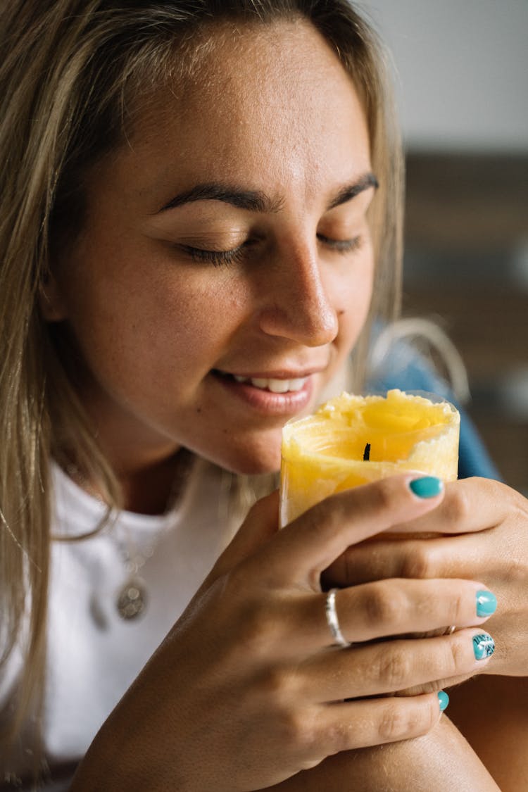 Woman Smelling A Candle