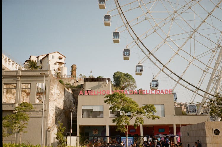 Observation Wheel Near Old House Facades In City