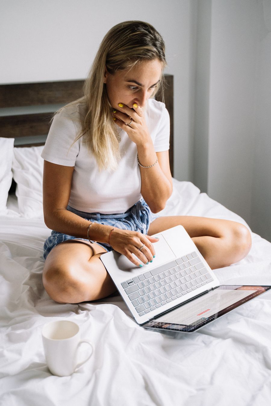 Vrouw ziet geschokt op haar laptop dat haar content op een lek-site staat