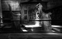 单色灯光照亮了复杂的木制教堂长凳，展现出神圣的建筑之美