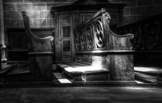 单色灯光照亮了复杂的木制教堂长凳，展现出神圣的建筑之美