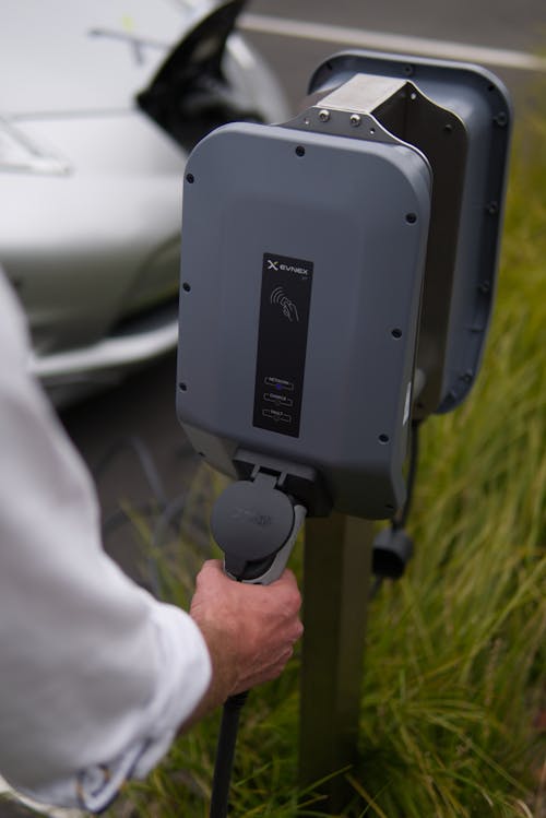 Close-Up View of a Person Holding the EV Charger