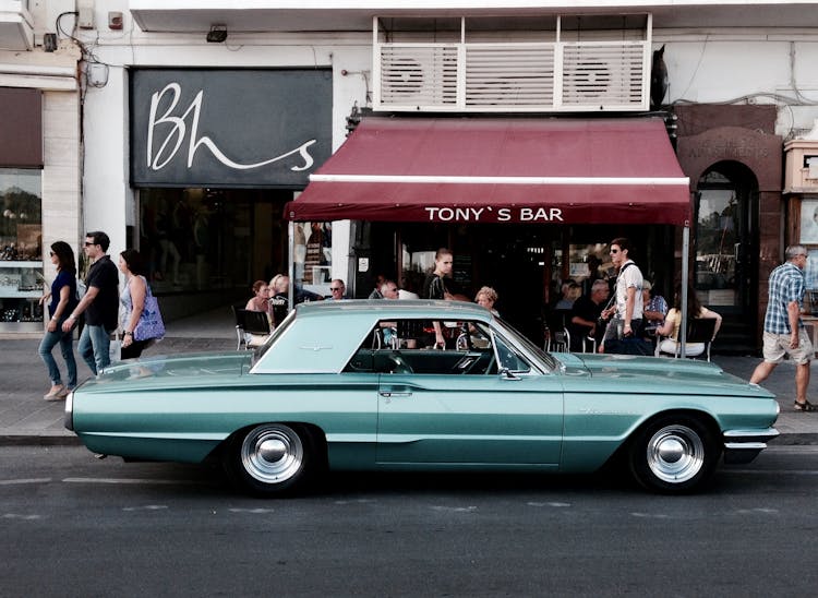 Teal Car Parked In Front Of A Bar