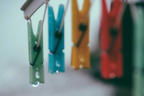 Free Closeup vivid clothes pegs with dripping water drops hanging on ropes at daytime Stock Photo
