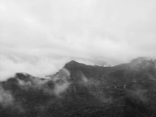 Free Grayscale Photo of Mountains Under Cloudy Sky Stock Photo