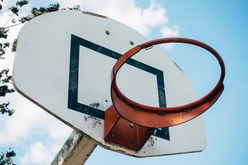 Free Close-up view of a basketball hoop and backboard under a clear blue sky. Stock Photo