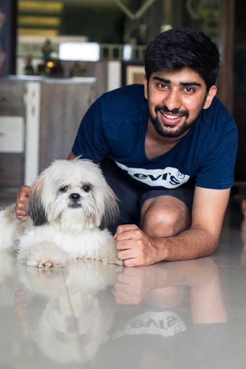Man in Blue Shirt Smiling with His Dog