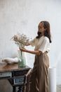 Woman Putting Flowers into a Glass Vase 