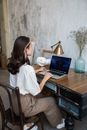 Woman in White Shirt Sitting on Chair Using Laptop Computer