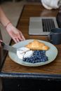 Person Holding Knife Slicing Bread on Brown Wooden Chopping Board