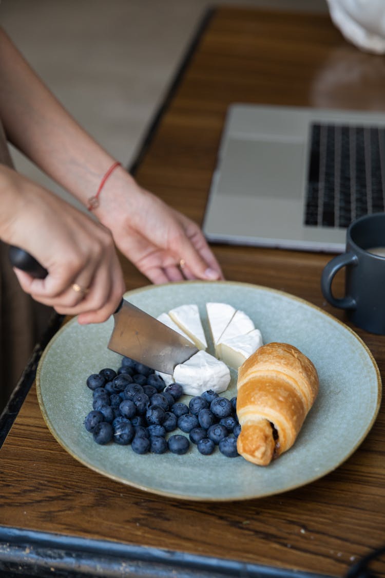 Woman Cutting A Camembert On A Plate 