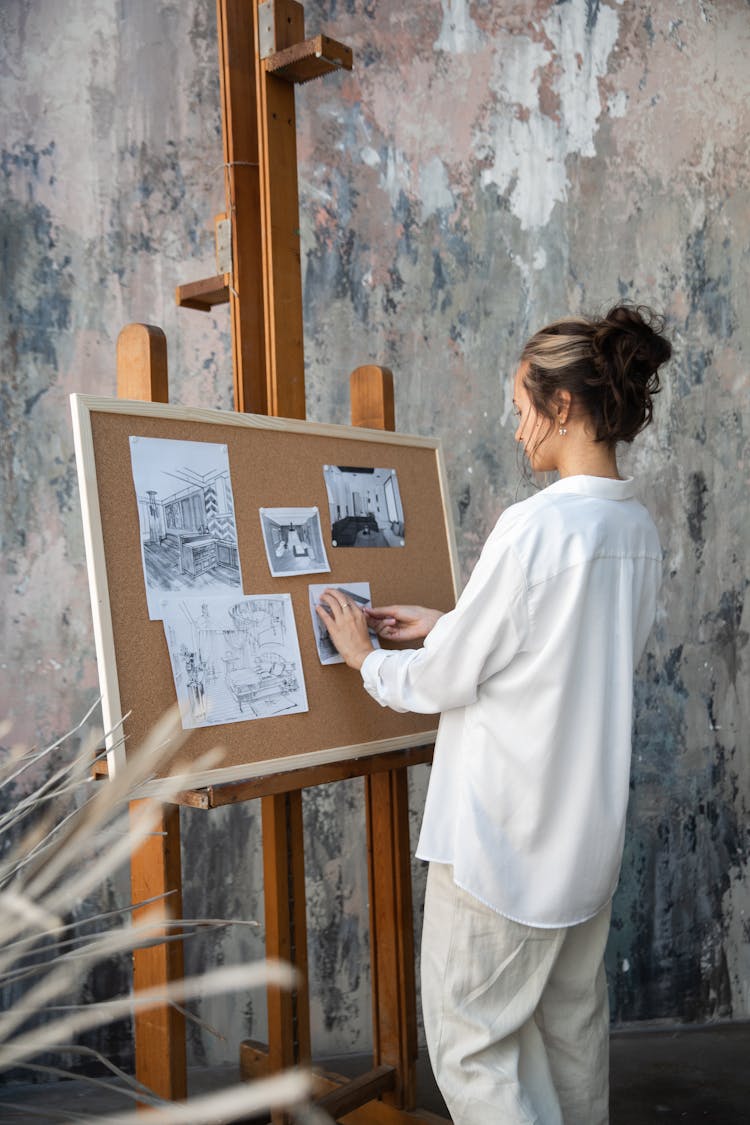 Woman Sticking Drawing On A Board