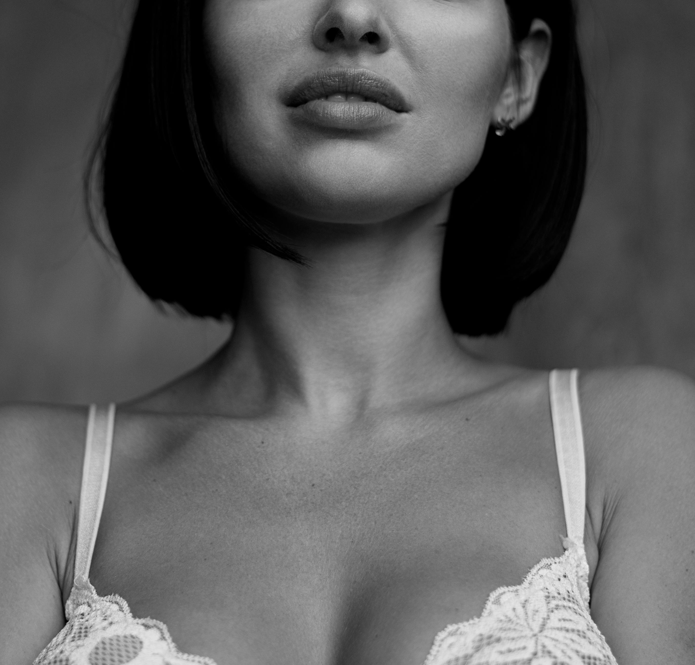 Monochrome close-up portrait of a woman in lace attire showcasing elegance.