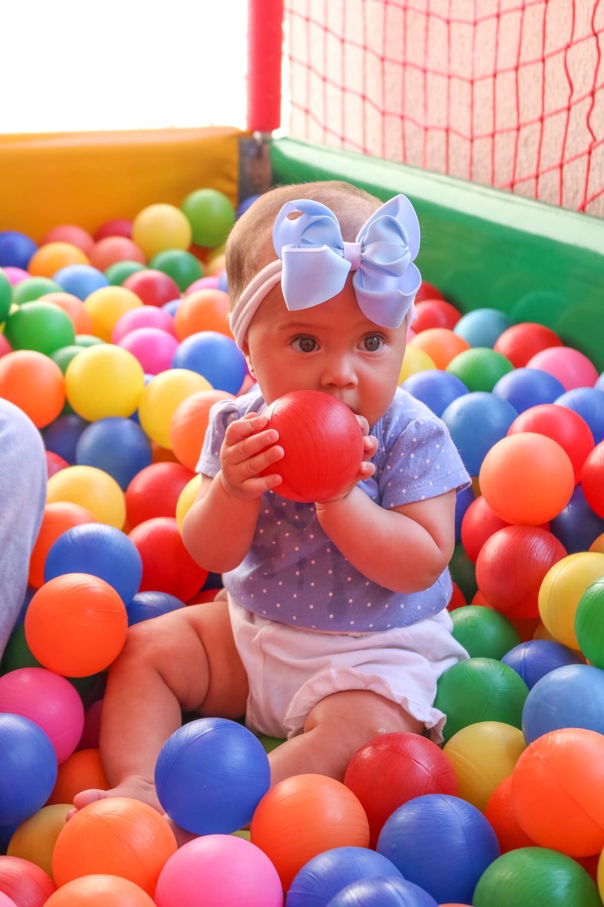 Happy baby playing in a colourful ball pit