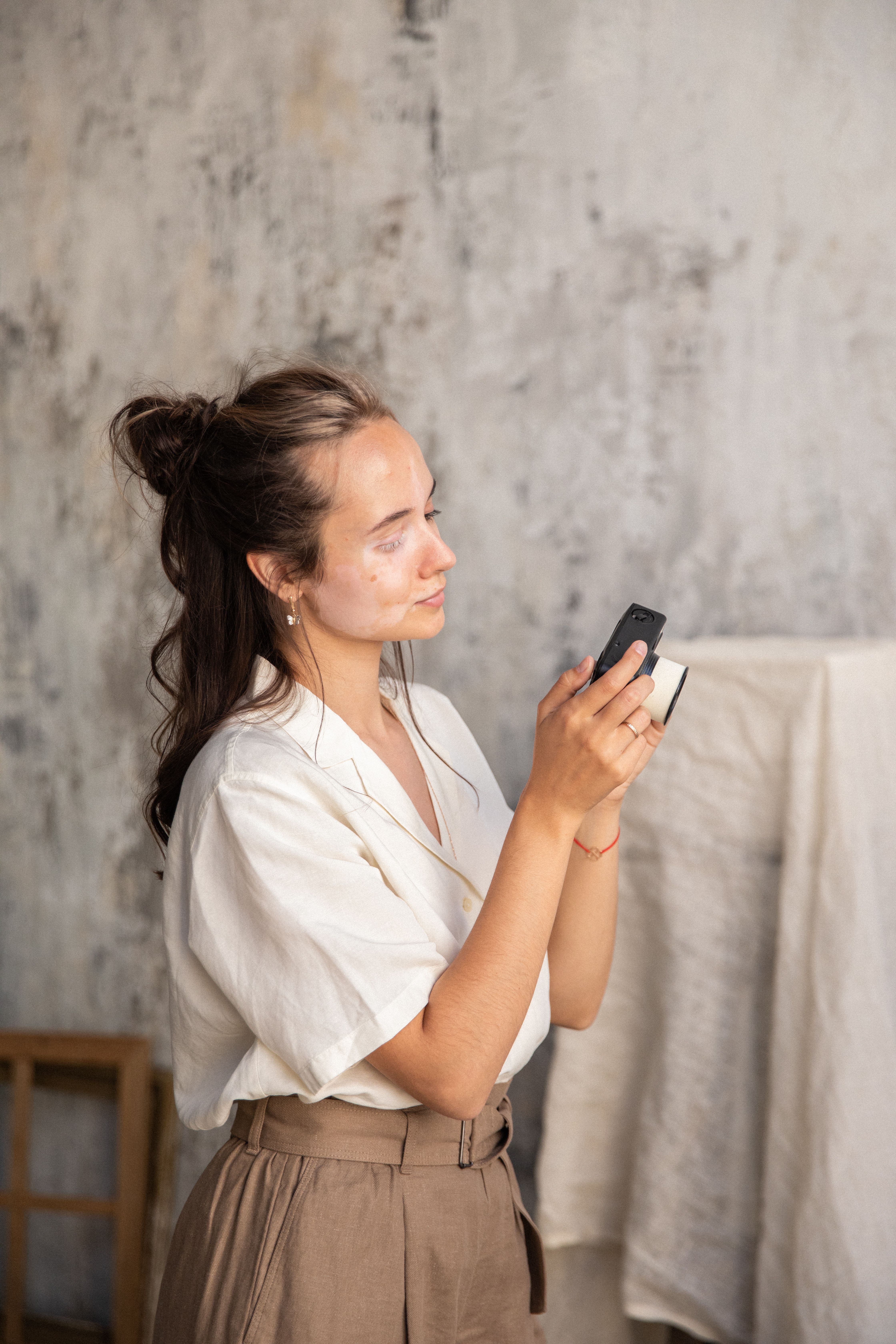 A Woman in White Top and Brown Pants Looking at a Camera · Free Stock Photo