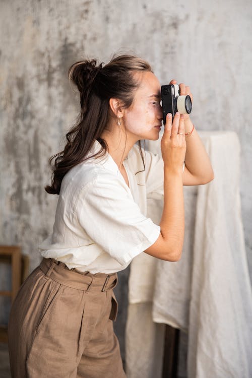 Free A Woman in White Top and Brown Pants Taking Photos Stock Photo